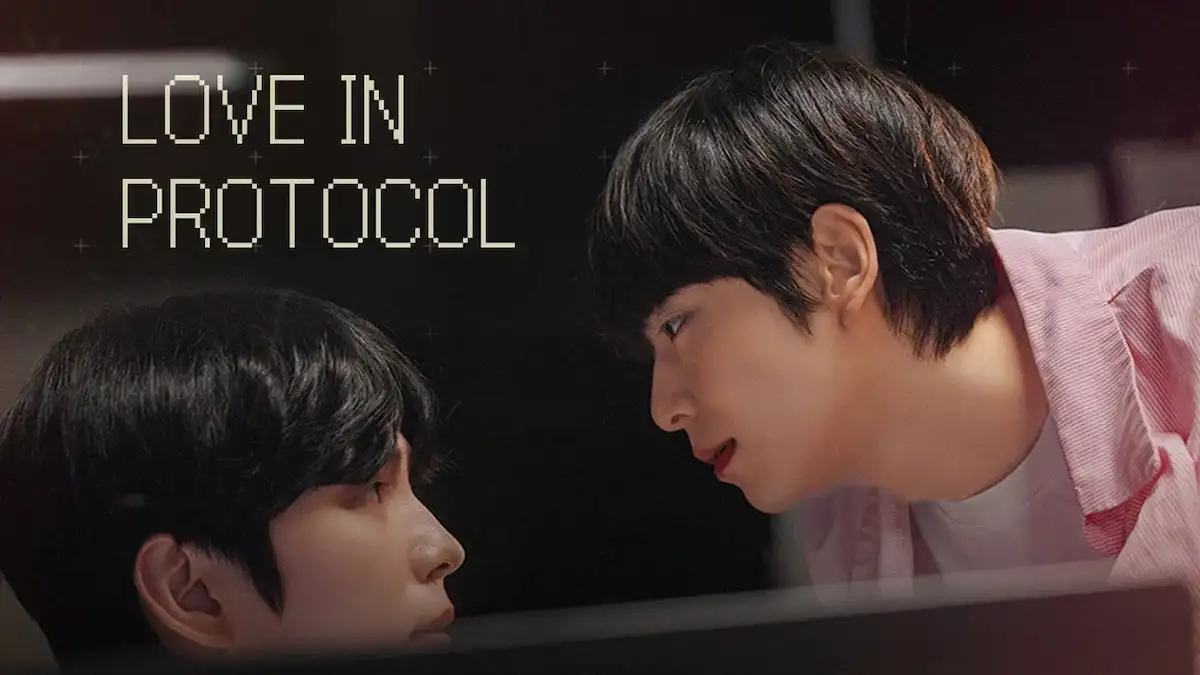 Two young men looking at each other closely over a computer monitor in a dimly lit office with title text Love In Protocol