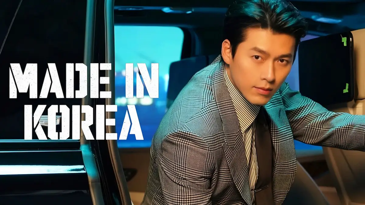 A man in a houndstooth suit leaning out of a car door looking toward the camera